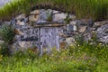 Beautiful wildflowers accent root cellar wooden door and stone wall Royalty Free Stock Photo