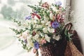 Beautiful wildflowers in wicker bag on rustic white window. colo Royalty Free Stock Photo