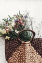 beautiful wildflowers in wicker bag on rustic white wooden background flat lay. colorful flowers in basket in light, space for te Royalty Free Stock Photo