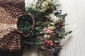 beautiful wildflowers in wicker bag on rustic white wooden background flat lay. colorful flowers in basket in light, space for te Royalty Free Stock Photo