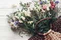 beautiful wildflowers in wicker bag on rustic white wooden background flat lay. colorful flowers in basket in light, space for te Royalty Free Stock Photo