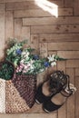 beautiful wildflowers in wicker bag and woman shoes on rustic wooden background top view. flowers in basket and girl sandals, spa Royalty Free Stock Photo