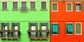 Beautiful windows with green shutters and balcony with flowers on red and green wall. Colorful houses on Burano island near Venice Royalty Free Stock Photo