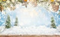Beautiful winter background with wooden old desk, fir trees and blurred blue sky. Winter, New Year and Christmas concept with Royalty Free Stock Photo
