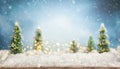 Beautiful winter background with wooden old desk, fir trees and blurred blue sky. Winter, New Year and Christmas concept with Royalty Free Stock Photo