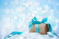 Beautiful winter composition with Christmas gift or present box in snow against holiday lights background Royalty Free Stock Photo