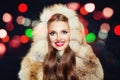 Beautiful winter girl with red nails in fur hood with colorful bokeh Royalty Free Stock Photo