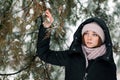 Beautiful winter girl stands in the park between the snowy trees Royalty Free Stock Photo