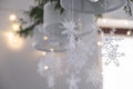 Beautiful winter interior decoration. White knitted snowflakes hang on a chandelier in the Christmas house.