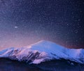 Beautiful winter landscape in the Carpathian mountains. Vibrant night sky with stars and nebula and galaxy. Deep sky Royalty Free Stock Photo