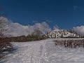 Winter landscape with footprints in snow on white meadow with grass and bushes and KornbÃÂ¼hl hill in Swabian Alb, Germany. Royalty Free Stock Photo