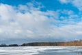 Beautiful winter landscape forest on the lake shore on a sunny frosty day. Panorama of the coastline covered with snow and birch Royalty Free Stock Photo