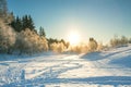 Winter landscape with forest, snow, blue sky and sun Royalty Free Stock Photo