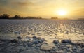 Beautiful winter landscape with frozen lake and sunset sky. Royalty Free Stock Photo