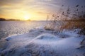 Beautiful winter landscape with frozen lake and sunset sky. Royalty Free Stock Photo