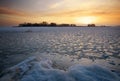 Beautiful winter landscape with frozen lake and sunset sky. Royalty Free Stock Photo