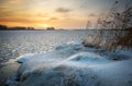 Beautiful winter landscape with frozen lake and sunset sky. Royalty Free Stock Photo