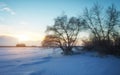Beautiful winter landscape with frozen lake, trees and sunset