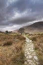 Beautiful Winter landscape image looking along valley from Crimpiau towards Mount Snowdon in the distance