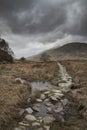 Beautiful Winter landscape image looking along valley from Crimpiau towards Mount Snowdon in the distance