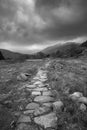 Beautiful Winter landscape image looking along valley from Crimpiau towards Mount Snowdon in the distance in black and white