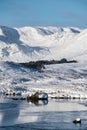Beautiful Winter landscape image looking towards Scottish Highlands mountain range across Loch Ba on Rannoch Moor Royalty Free Stock Photo