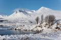 Beautiful Winter landscape image looking towards Scottish Highlands mountain range across Loch Ba on Rannoch Moor Royalty Free Stock Photo