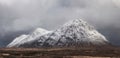 Beautiful Winter landscape image of Stob Dearg Buachaille Etive Mor viewed from Rannoch Moor with snowcapped peak and beautiful Royalty Free Stock Photo
