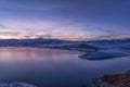 Panoramic view on the lake and mountains peaks snow-covered after sunset. Royalty Free Stock Photo
