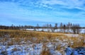 Beautiful winter landscape with snow-covered field and blue cloudy sky. Nature of Eastern Siberia. Royalty Free Stock Photo