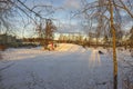 Beautiful winter landscape. Snow-covered hill where children go sledding and snowboarding with their parents in cottage village. Royalty Free Stock Photo