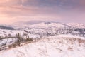 Beautiful winter landscape in soft sunset light, alpine valley surrounded by wooded mountains Royalty Free Stock Photo