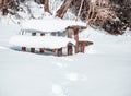 Beautiful winter landscape with a wooden table covered with a thick layer of snow. Resting place for hikers in the woods Royalty Free Stock Photo