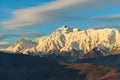 Beautiful winter mountain landscape of Main Caucasus ridge with scenic snowy Chugush mountain peak and blue sky at sunset Royalty Free Stock Photo