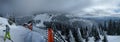 Panoramic view of mountain with a skier and a safety net.