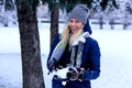 Beautiful winter portrait of young woman in the winter snowy scenery. Beautiful girl in winter clothes. Royalty Free Stock Photo