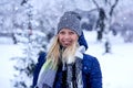 Beautiful winter portrait of young woman in the winter snowy scenery. Beautiful girl in winter clothes. Royalty Free Stock Photo