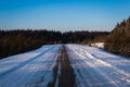 Beautiful winter road through snowy fields,sunset and forests