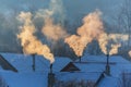 Beautiful winter scenery with smoke coming from house chimneys, on a bright, cold, morning, in remote countryside in Europe