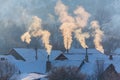 Beautiful winter scenery with smoke coming from house chimneys, on a bright, cold, morning, in remote countryside in Europe