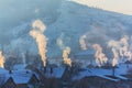 Beautiful winter scenery with smoke coming from house chimneys, on a bright, cold, morning, in remote countryside in Europe