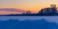 A beautiful winter sunrise scenery of frozen lake and forest. Colorful landscape with dawn skies Royalty Free Stock Photo