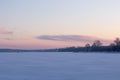 A beautiful winter sunrise scenery of frozen lake and forest. Colorful landscape with dawn skies Royalty Free Stock Photo