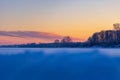 A beautiful winter sunrise scenery of frozen lake and forest. Colorful landscape with dawn skies Royalty Free Stock Photo