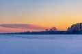 A beautiful winter sunrise scenery of frozen lake and forest. Colorful landscape with dawn skies Royalty Free Stock Photo