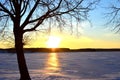 Beautiful winter sunset on a background of a frozen lake. Winter arrives, bodies of water freeze over, People walk on ice of the