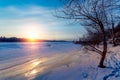 Beautiful winter sunset with trees in the snow and frozen river Royalty Free Stock Photo