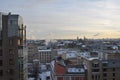 Beautiful winter view from above on the evening city. Roofs of houses in the snow, beautiful sky with clouds. Pipes smoke away. Royalty Free Stock Photo