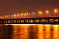 Beautiful winter view of the bridge, lanterns light reflected on the ice of the Dnieper River. Ukraine