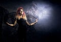 Beautiful witch making the witchcraft over the smoky background Royalty Free Stock Photo